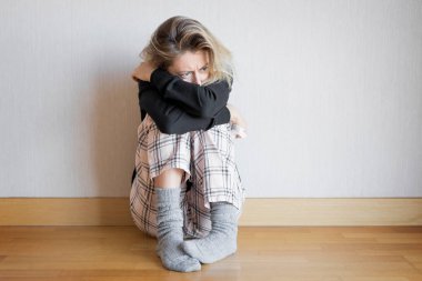 smutna kobieta siedzi na podłodze