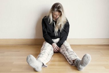 Katta oturan çaresiz ve üzgün kadın