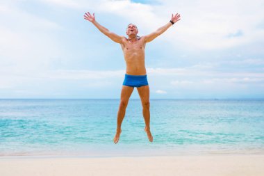 Mutlu bir adam sahilde atlamak
