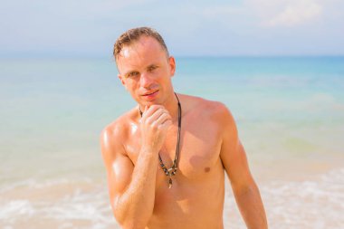 gömleksiz adam sahilde