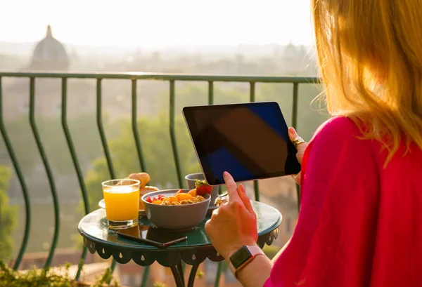 バルコニーで朝食中にタブレットを使用して女性 — ストック写真