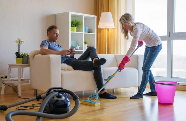 Frau Putzt Haus Und Mann Hilft Ihr Nicht — Stockfoto