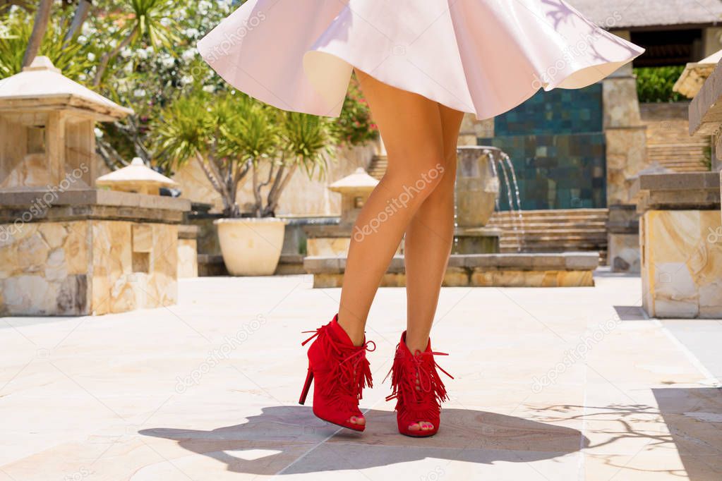 Woman in skirt and red high heel shoes
