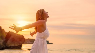 Mutlu kadının akşam günbatımı okyanus tarafından