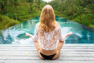 Kadın ormanda havuzun yanında meditasyon