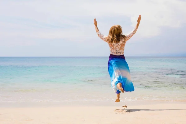 在海滩上跳跃的无忧无虑和快乐的女人 — 图库照片