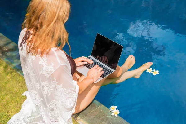 Havuz Kenarında Otururken Dizüstü Bilgisayar Kullanan Kadın — Stok fotoğraf