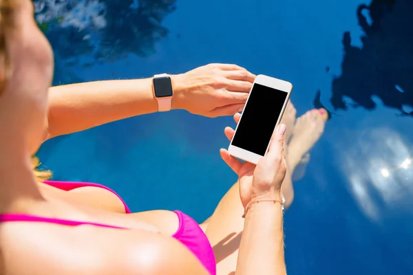 Vrouw Met Behulp Van Smartwatch Mobiele Telefoon Bij Het Zwembad — Stockfoto