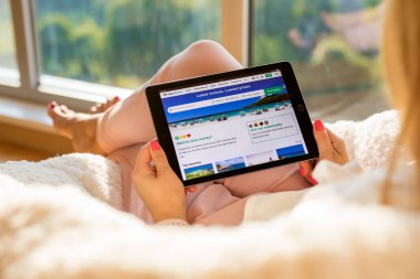 Riga, Letonya - 21 Temmuz 2018: Kadın ipad Tripadvisor sitesinde okuma.