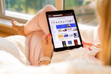 Riga, Letonya - 21 Temmuz 2018: kitaplar Amazon Web sitesinde ipad için alışveriş kadın.