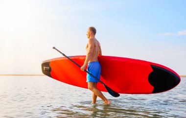 Sup tahtası ile suda yürüyen adam