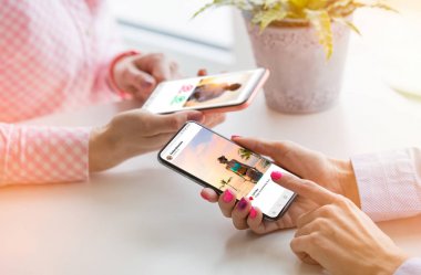 Cep telefonlarını birlikte kullanan iki kadın