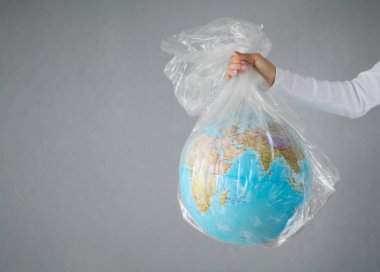 Plastik torbaiçinde dünya gezegeni dışarı atma kişi