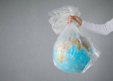 Plastik torbaiçinde dünya gezegeni dışarı atma kişi