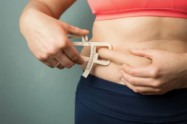 胖女人使用身体脂肪卡钳 — 图库照片