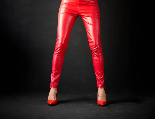 Woman wearing red leather pants and red high heel shoes