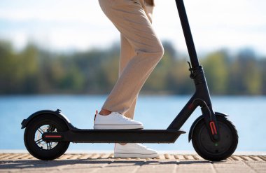 Elektrikli scooter 'ın üzerinde duran kadın
