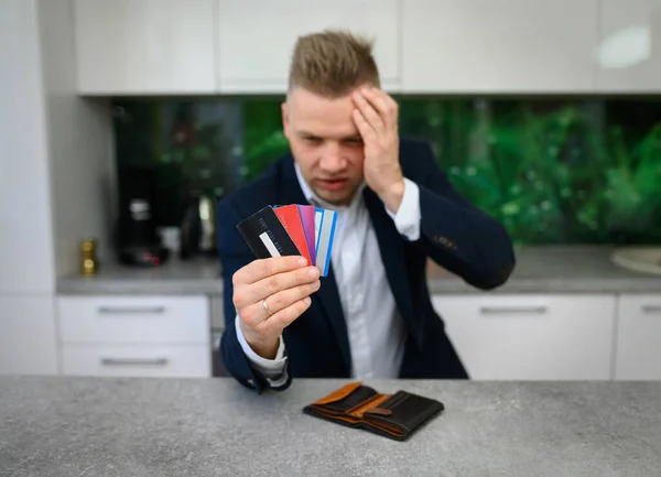 Hombre Preocupado Mirando Sus Tarjetas Crédito Vacías —  Fotos de Stock