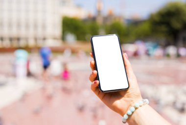 Şehirde akıllı telefon tutan kişi, boş beyaz ekranlı telefon modeli..