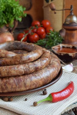 Geleneksel Tütsülenmiş sosis halka bir rustik tarzda. İştah açıcı sosis domuz eti ve taze otlar ile kuzu yapılmış ahşap gemide baharat. Metin için boş alan