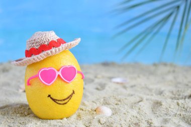 Yaratıcı en az yaz fikir. Pembe güneş gözlüğü ve bambu şapka kum üzerinde limon narenciye hippi. Tropikal plaj kavramı. Yaratıcı sanat. Kopya alanı.