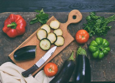 BIO organik taze yaz sebze - patlıcan ahşap kesme tahtası üzerinde dilimlenmiş. Yemek pişirmek için malzemeler. Sağlıklı gıda. Ham foodism. Kopya alanı.