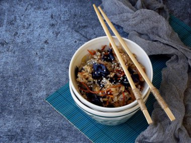 Sebzeler, havuç, mor lahana, soğan ile pirinç çubuklar gri arka plan üzerine susam serpilir. Sağlıklı vejetaryen yemek. Metin için yer.