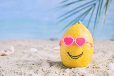 Yaratıcı en az yaz fikir. Limonlu narenciye hippi kum üzerinde güneş gözlüğü. Tropikal plaj kavramı. Yaratıcı sanat. Kopya alanı.