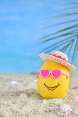 Yaratıcı en az yaz fikir. Pembe güneş gözlüğü ve bambu şapka kum üzerinde limon narenciye hippi. Tropikal plaj kavramı. Yaratıcı sanat. Kopya alanı.