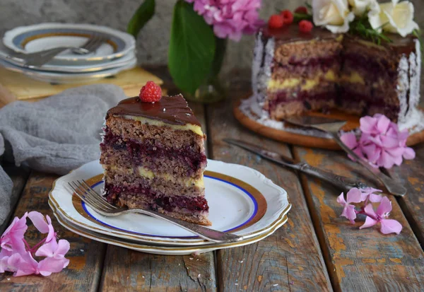 Gluten-free and dairy-free cake decorated with white roses and coconut: chocolate-nut biscuit, berry mousse, custard on almond milk and chocolate glaze. Healthy dietary baking. Vegetarian food