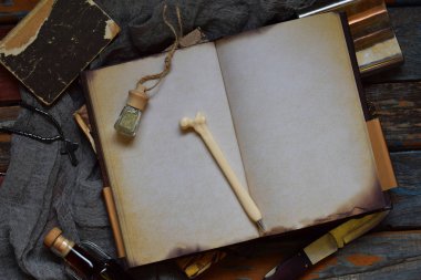 Şeyler avcı için kötü, şeytanlar, vampirler ve zombi - eski bir defter, büyü ile bir kitap, bir bıçak, şişe kutsal su, kalem kemik, alkol, bir haç. Karanlık bir arka plan üzerinde Erkek aksesuarlar