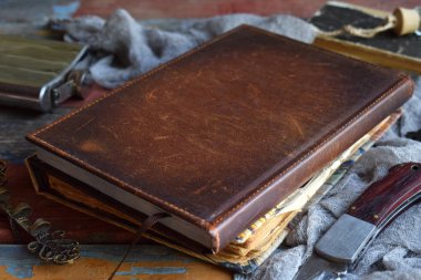 Şeyler avcı için kötü, şeytanlar, vampirler ve zombi - eski bir defter, büyü ile bir kitap, bir bıçak, şişe kutsal su, kalem kemik, alkol, bir haç. Karanlık bir arka plan üzerinde Erkek aksesuarlar