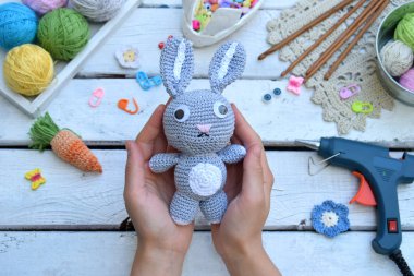 Tavşan havuç ile yapım. Bunny çocuk için tığ işi. Tablo konu üzerinde iğneler, kanca, pamuk ipliği. El yapımı el sanatları. DIY kavramı. Küçük işletme. Hobi geliri