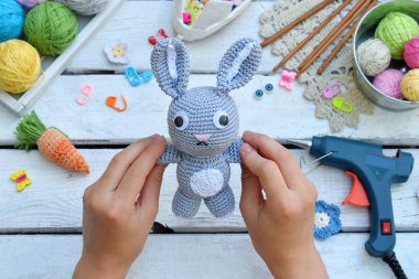 Tavşan havuç ile yapım. Bunny çocuk için tığ işi. Tablo konu üzerinde iğneler, kanca, pamuk ipliği. El yapımı el sanatları. DIY kavramı. Küçük işletme. Hobi geliri