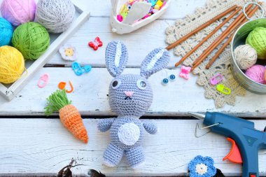 Tavşan havuç ile yapım. Bunny çocuk için tığ işi. Tablo konu üzerinde iğneler, kanca, pamuk ipliği. El yapımı el sanatları. DIY kavramı. Küçük işletme. Hobi geliri
