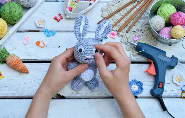Tavşan havuç ile yapım. Bunny çocuk için tığ işi. Tablo konu üzerinde iğneler, kanca, pamuk ipliği. Adım 3 - oyuncak gözünde tutkal. El yapımı el sanatları. DIY kavramı. Küçük işletme. Hobi geliri