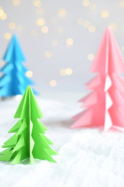 Origami Kağıt beyaz arka plan ve bokeh ışıkları üzerinde 3d Xmas ağacı. Merry Christmas ve yeni yıl kartı. Kağıt sanat tarzı. Uzay kopyalayın. Seçici odak.