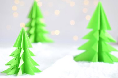 Origami Kağıt beyaz arka plan ve bokeh ışıkları üzerinde 3d Xmas ağacı. Merry Christmas ve yeni yıl kartı. Kağıt sanat tarzı. Uzay kopyalayın. Seçici odak.