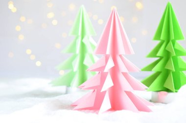 Origami Kağıt beyaz arka plan ve bokeh ışıkları üzerinde 3d Xmas ağacı. Merry Christmas ve yeni yıl kartı. Kağıt sanat tarzı. Uzay kopyalayın. Seçici odak.
