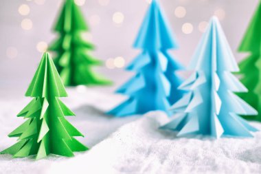 Origami Kağıt beyaz arka plan ve bokeh ışıkları üzerinde 3d Xmas ağacı. Merry Christmas ve yeni yıl kartı. Kağıt sanat tarzı. Uzay kopyalayın. Seçici odak.