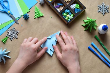 Kağıt dekorasyon veya tebrik kartı yapımı origami 3d Xmas ağacı. Mutlu Noeller ve mutlu yeni yıl. Çocuk DIY kavramı. Kendi ellerinle tatilde el yapımı el sanatları