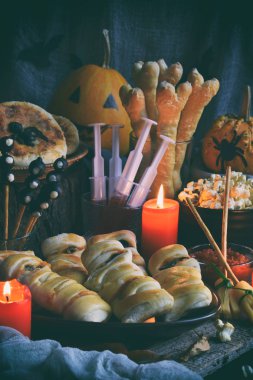 Cadılar Bayramı hüner ya da muamele etmek parti. Komik lezzetli yemekleri ve ahşap arka plan - mini pizza, ekmek sopa, peynir, zeytin, ketçap, patlamış mısır, kabak suyu. Metin için yer kopyalayın