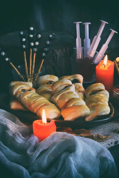 Cadılar Bayramı hüner ya da muamele etmek parti. Komik lezzetli yemekleri ve ahşap arka plan - mini pizza, ekmek sopa, peynir, zeytin, ketçap, patlamış mısır, kabak suyu. Metin için yer kopyalayın