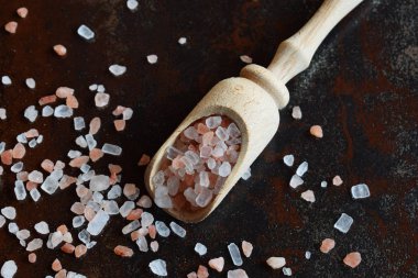 Tahta kaşık siyah arka plan üzerine kaba pembe tuz. Himalaya tuz. Kopya alanı.