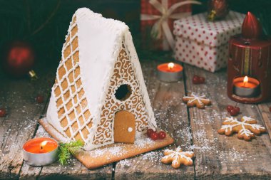 Çamın dalları, koniler ile bisküvi koyu arka plan üzerinde ev yapımı kurabiye evi. Avrupa Noel gelenekleri. Xmas tatil tatlılar.