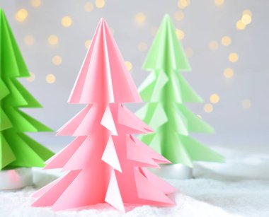 Origami Kağıt beyaz arka plan ve bokeh ışıkları üzerinde 3d Xmas ağacı. Merry Christmas ve yeni yıl kartı. Kağıt sanat tarzı. Uzay kopyalayın. Seçici odak.