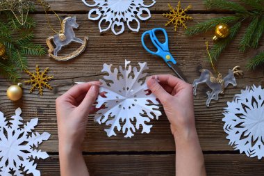 Kağıt kar taneleri kendi elleriyle yapıyor. Çocuk DIY. Merry Christmas ve yeni yıl kavramı