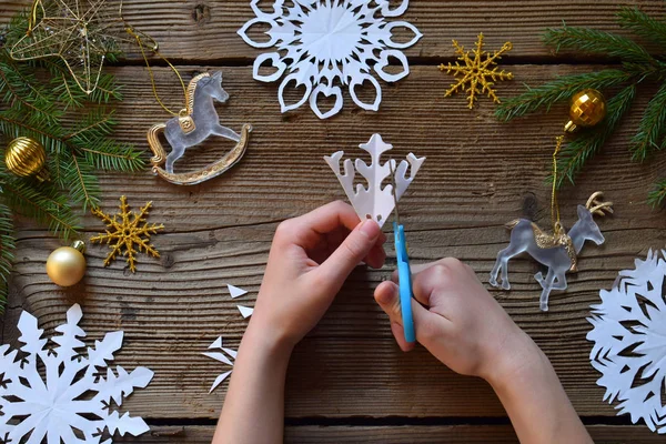 Making paper snowflakes with your own hands. Children\'s DIY. Merry Christmas and New Year concept. Step 2. Cut the snowflake.