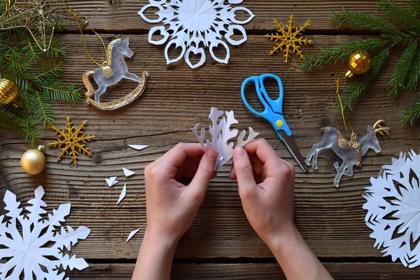 Making paper snowflakes with your own hands. Children's DIY. Merry Christmas and New Year concept. Step 3. Open the snowflake.