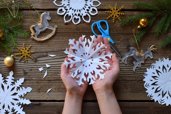 Kağıt kar taneleri kendi elleriyle yapıyor. Çocuk DIY. Merry Christmas ve yeni yıl kavramı